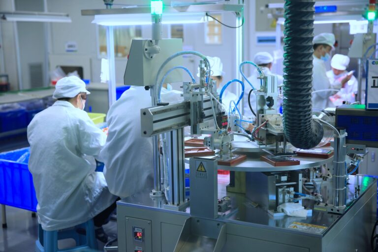 Automated electronic assembly line in RP Group Ltd's cleanroom facility, with technicians monitoring the precision equipment.