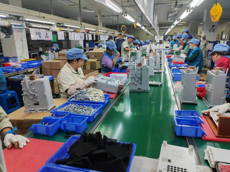 Workers on the production assembly line at RP Group Limited's factory in Zhong Shan, diligently assembling electronic components.
